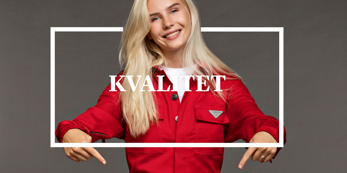 Blond ung russejente i rød dress peker nedover med begge hender